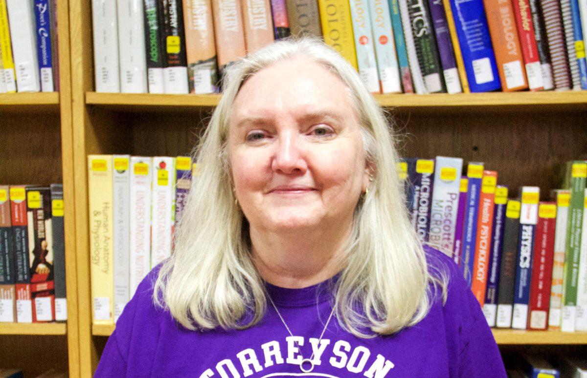 Librarian Sandra Hooper stands in front of a row of books in the Torreyson Library. Hooper has worked at the library for 21 years.