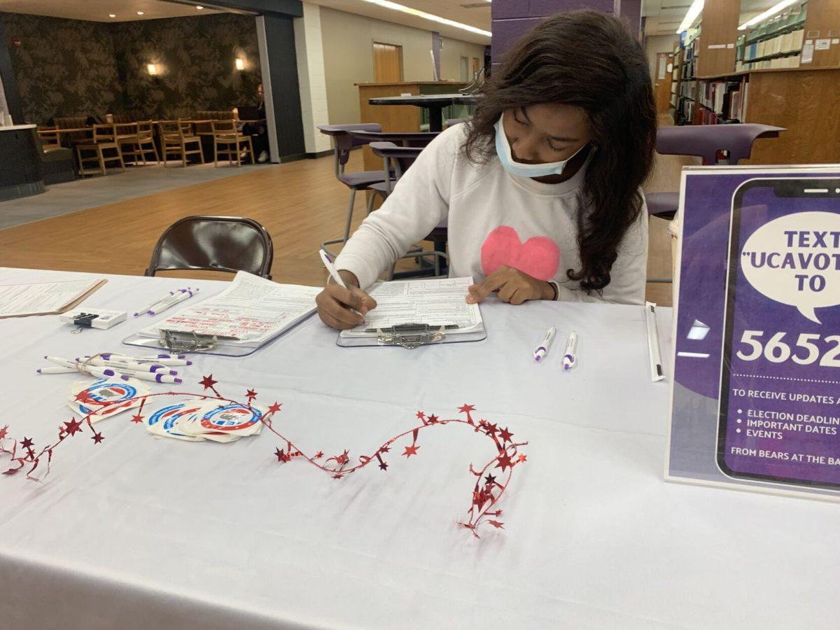 Freshman Denasia Hardin registers to vote at the booth hosted inside Torreyson Library. The booth was put on by Vote Everywhere and Invisible Little Rock and Central Arkansas. 