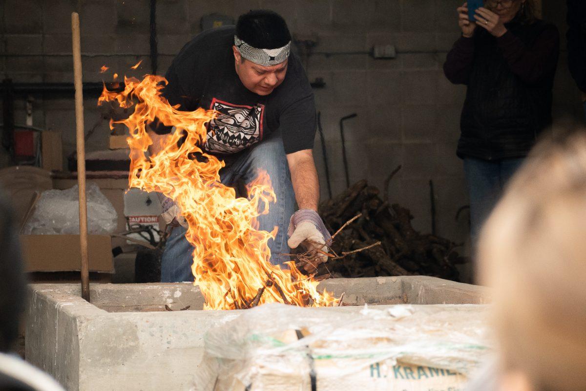 Chase Kahwinhut Earles demonstrates traditional pit firing method used to make Caddo pottery. He demonstrated the pottery making on March 11 for his Artist in Residence appearances. 
