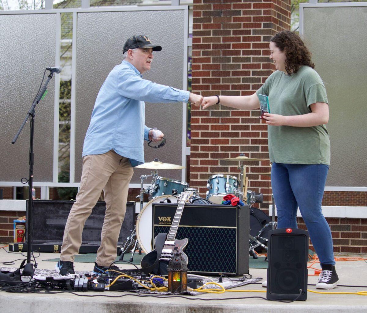 Associate professor Jim Deitrick fist bumps junior Cameron Steed after handing her the Outstanding Student in Religious Studies award. Steed is a religious studies major and won Best Scholarly Essay at the School of Communication Awards on April 14 for her essay “The Rhetoric of Televangelism.”