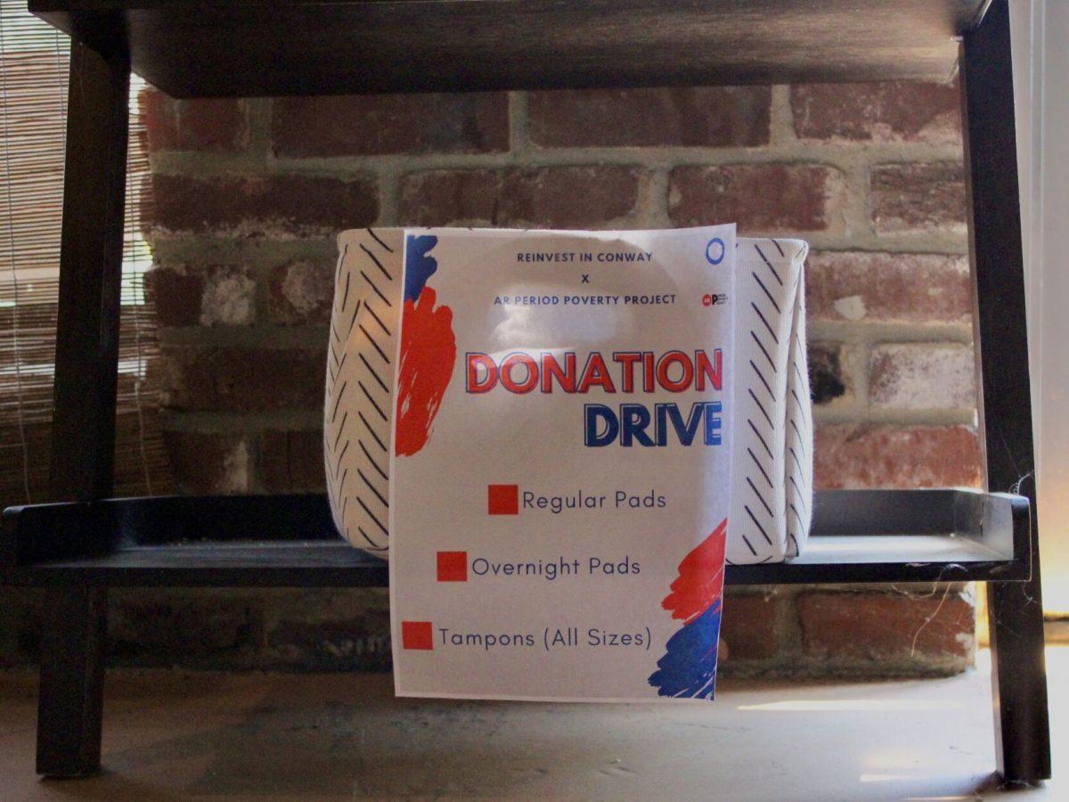A donation box for the period product drive sits under a table in Righteous Remedies.