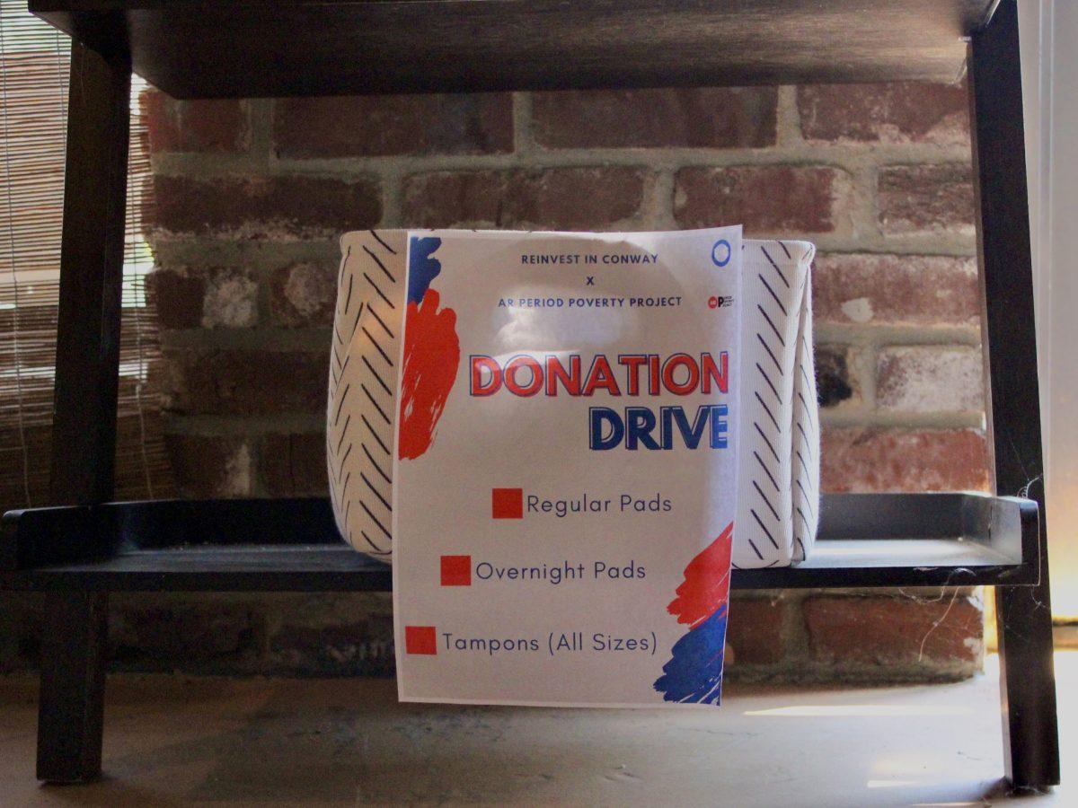 A donation box for the period product drive sits under a table in Righteous Remedies.