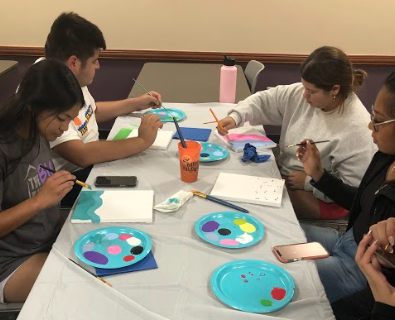 Students prepare to paint their canvases at “Painting with the SIAs.” A variety of colorful artwork was created at the event.