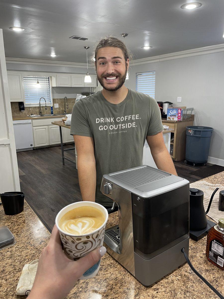 Senior biology major Caden Darby stands behind the counter of City Cafe. Darby is the owner of the temporary nonprofit at 1832 Robinson Ave.