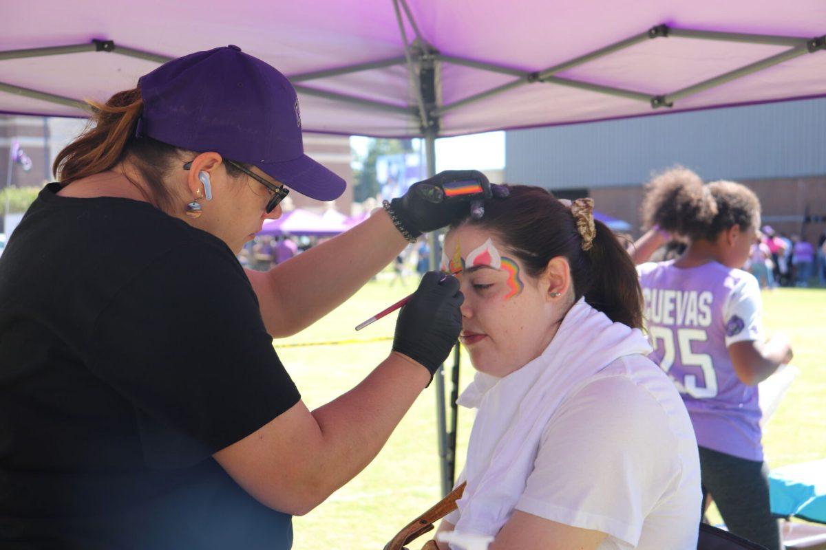 Ashley Stanley from Isabell Creek Face Painting paints freshman Felicity O’Reilly’s face.