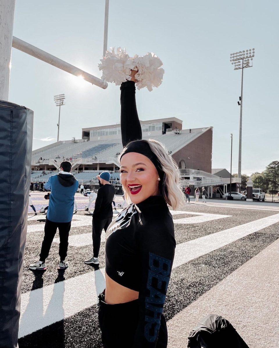 Helena Rawlings holds a pom pom in the air during a UCA football game. Rawlings is a freshman member of the Honey Bear Dance Team.