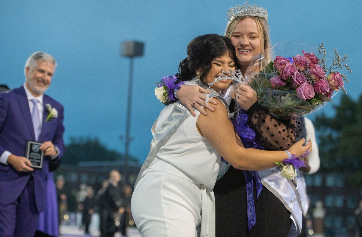 Homecoming Queen Gisselle Hernandez (middle) hugs 2021 Homecoming Queen Savannah Jessup (right) while President Houston Davis smiles (left).