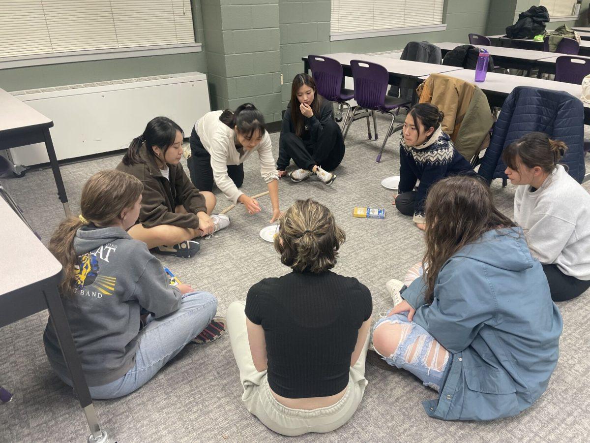 Attendees of the UCA Korean Club's game night sit in a circle with yut nori sticks and snacks in Irby Hall Nov. 17. The club put on the game night to allow attendees to experience traditional Korean games.