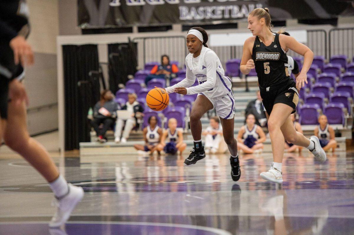 UCA freshman guard Parris Atkins (left) dribbles the ball ahead of Lindenwood senior guard Emily Benzschawel.