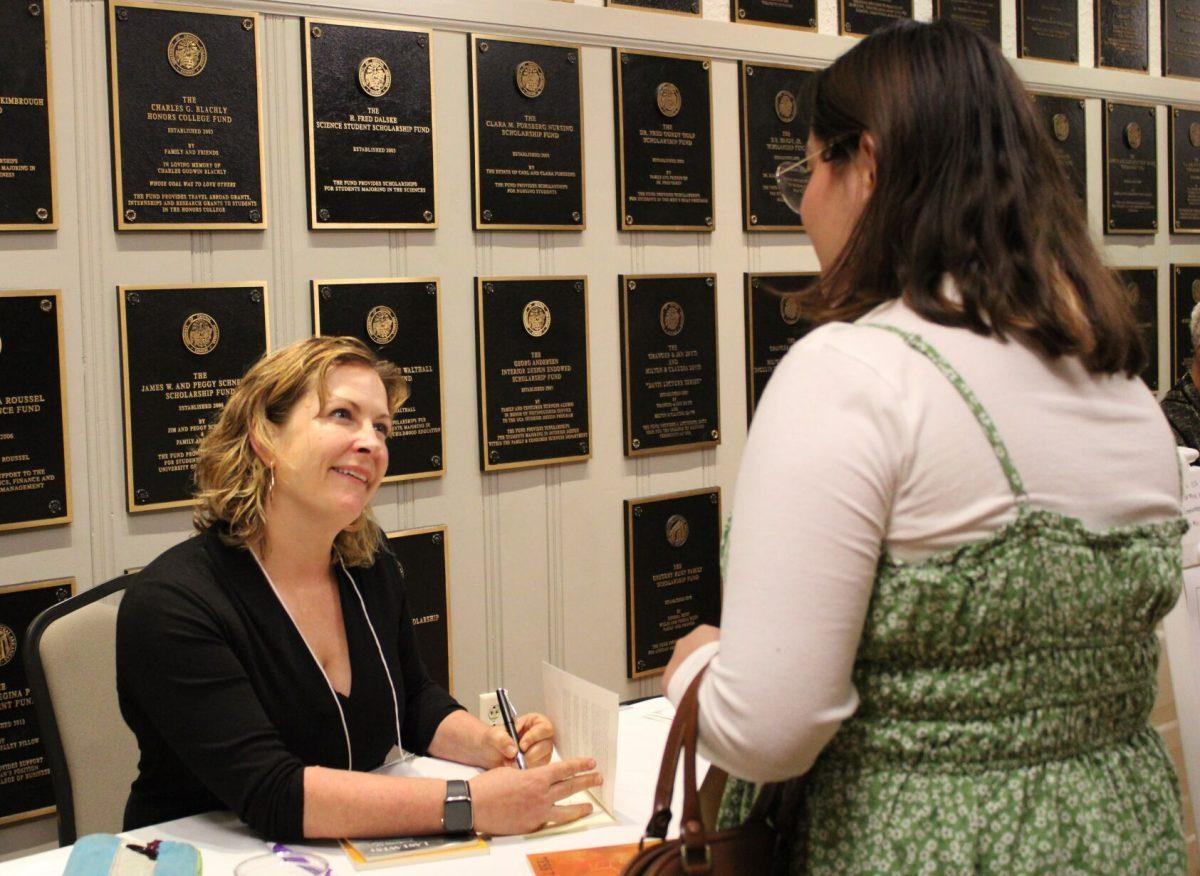Tess Taylor signs her autograph in a fan’s copy of her book “Last West: Roadsongs for Dorothea Lange.” The book was inspired by photographer Dorothea Lange’s visit to Taylor’s neighborhood in the 1940s. Taylor also led writing workshops and read book excerpts at the conference.