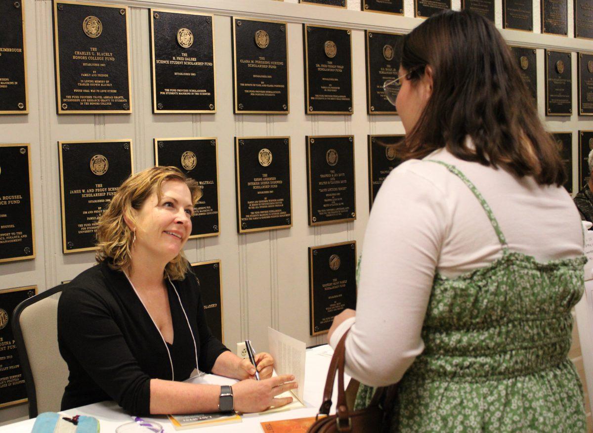 Tess Taylor signs her autograph in a fan’s copy of her book “Last West: Roadsongs for Dorothea Lange.” The book was inspired by photographer Dorothea Lange’s visit to Taylor’s neighborhood in the 1940s. Taylor also led writing workshops and read book excerpts at the conference.