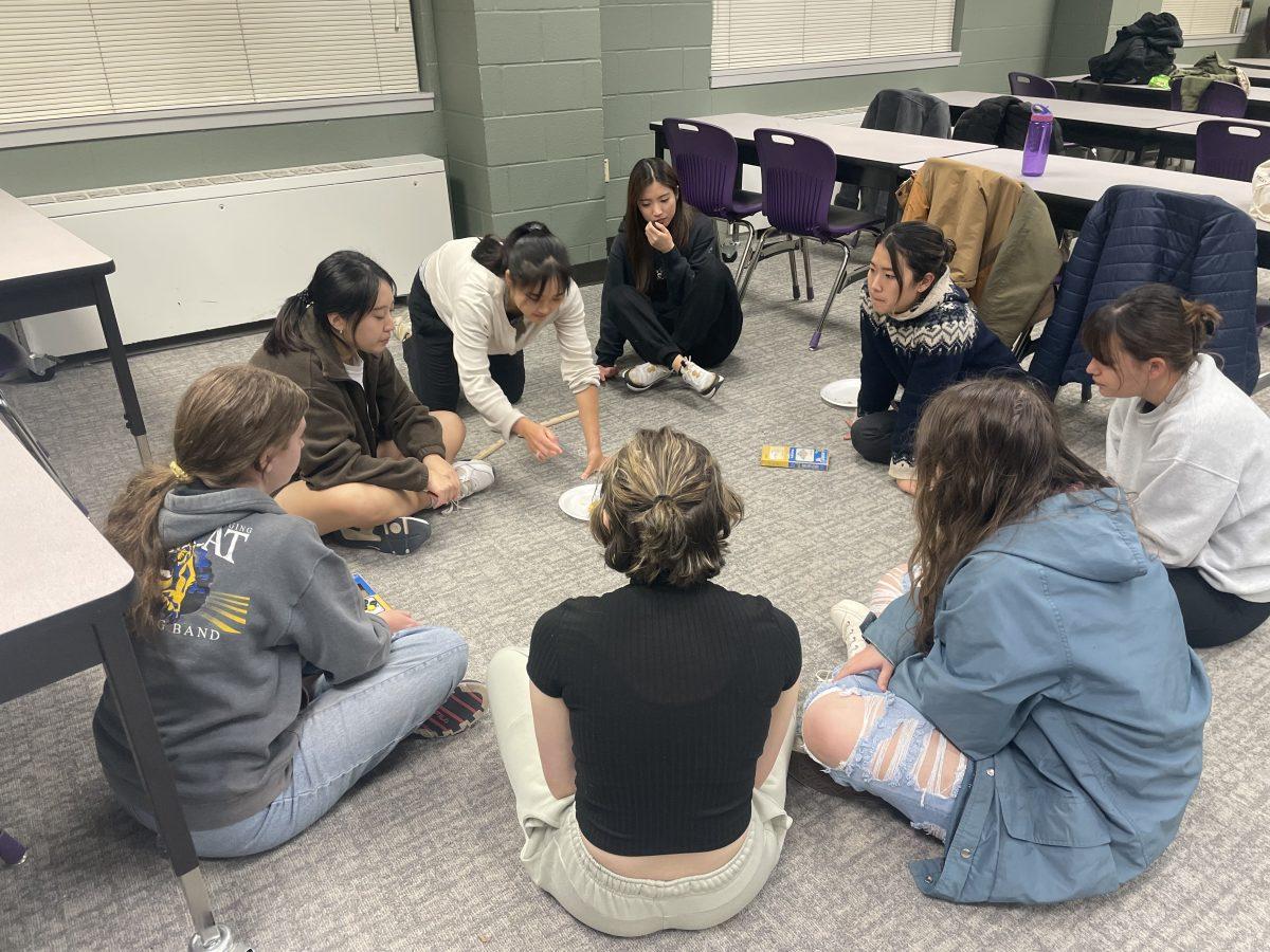 Attendees of the UCA Korean Club's game night sit in a circle with yut nori sticks and snacks in Irby Hall Nov. 17. The club put on the game night to allow attendees to experience traditional Korean games.
