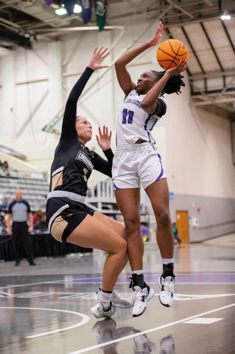 UCA junior forward Kyjai Miles (right) leaps for a basket over Lindenwood sophomore guard Paige Craft.