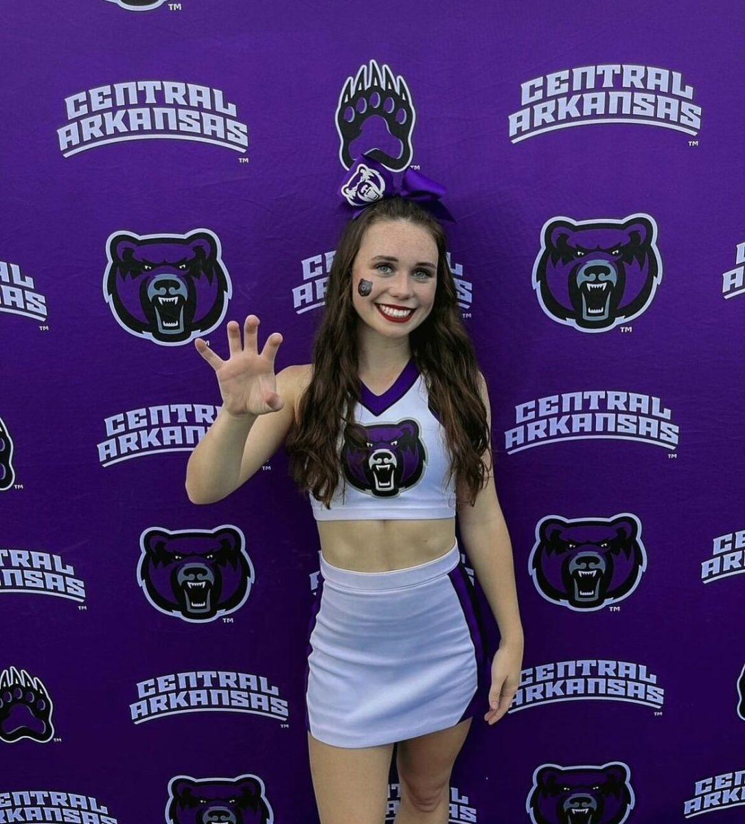 Sophomore Karli New puts her bear claws up in front of a UCA branded backdrop. New is a cheerleader for UCA’s cheerleading team and has cheered for eight years total.