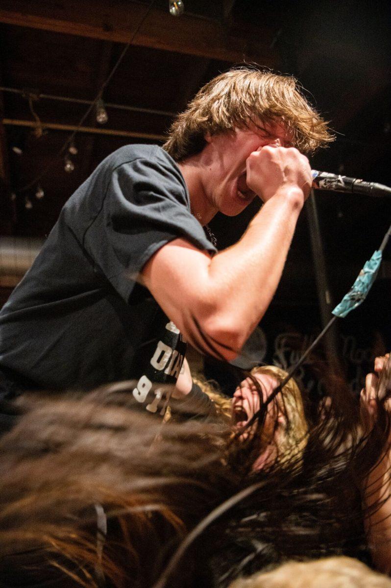 Jackson Edwards, vocalist for Zashed, spits energy into the crowd at Full Moon Records.
