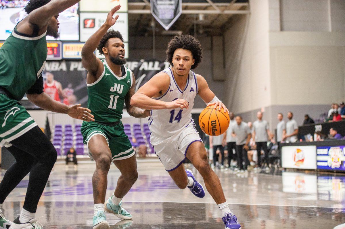 Junior guard Collin Cooper pushes past Jacksonville for a layup. The Bears lost 74-64, making this their eighth conference loss.