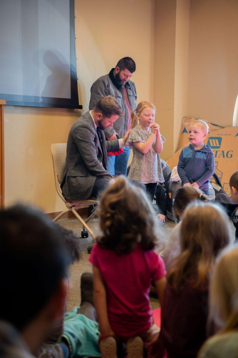 A child prays next to Strachan. While Strachan's church didn't sponsor "Pastor Story Hour," he said he designed the event to bring biblical lessons to children.