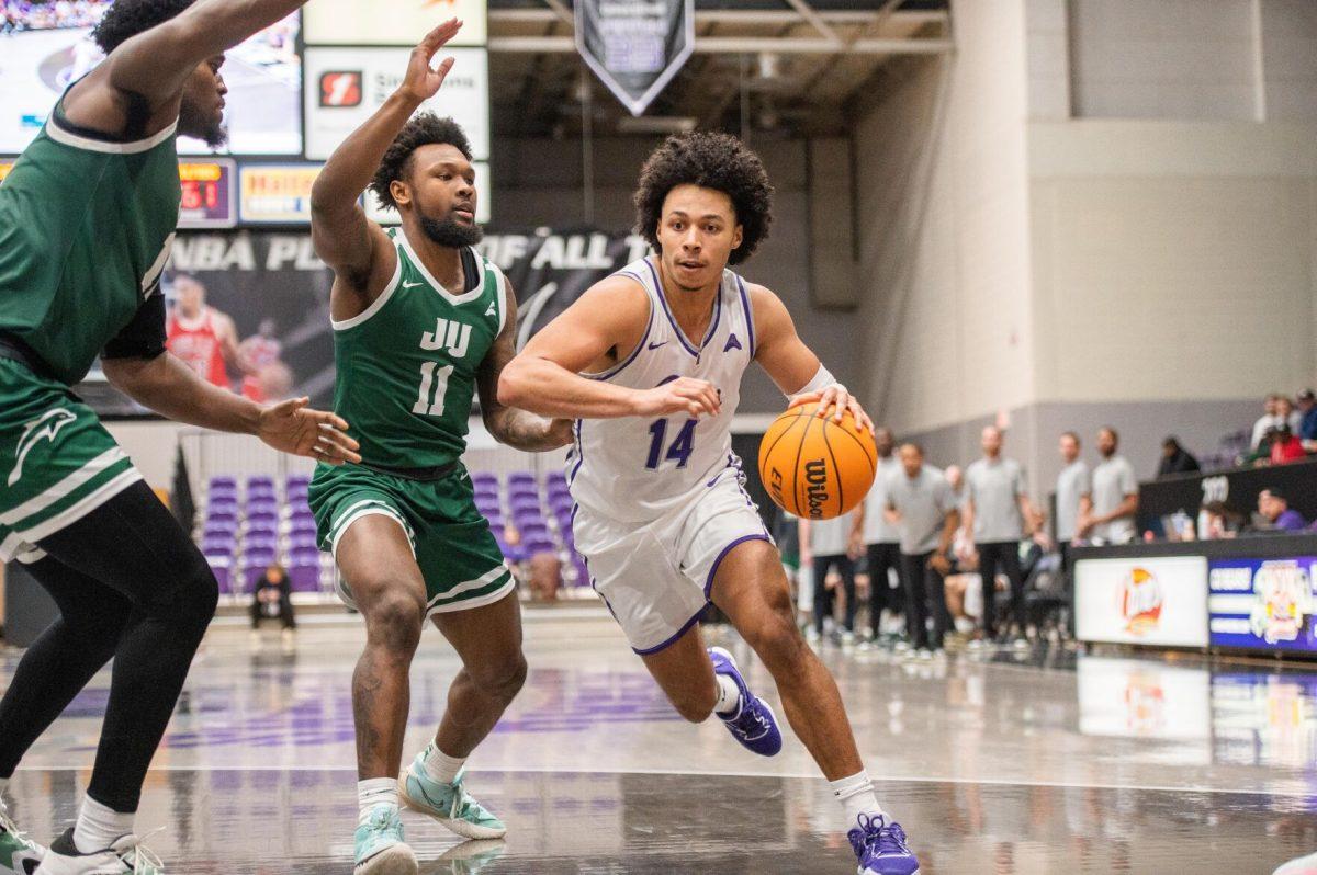 Junior guard Collin Cooper pushes past Jacksonville for a layup. The Bears lost 74-64, making this their eighth conference loss.