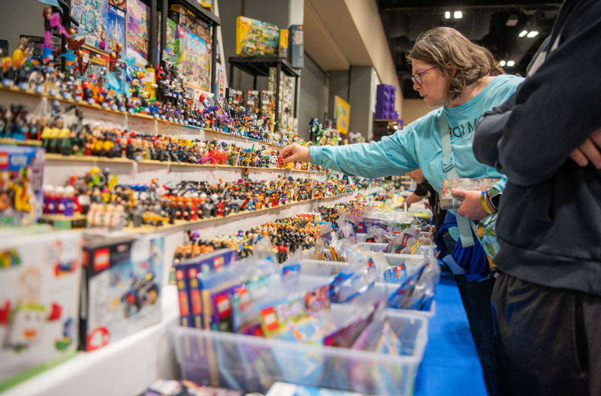 A woman reaches for a Lego minifigure being sold by It's A Block Party. The couple in charge of the business specialize in hard-to-find Lego sets and minifigures.