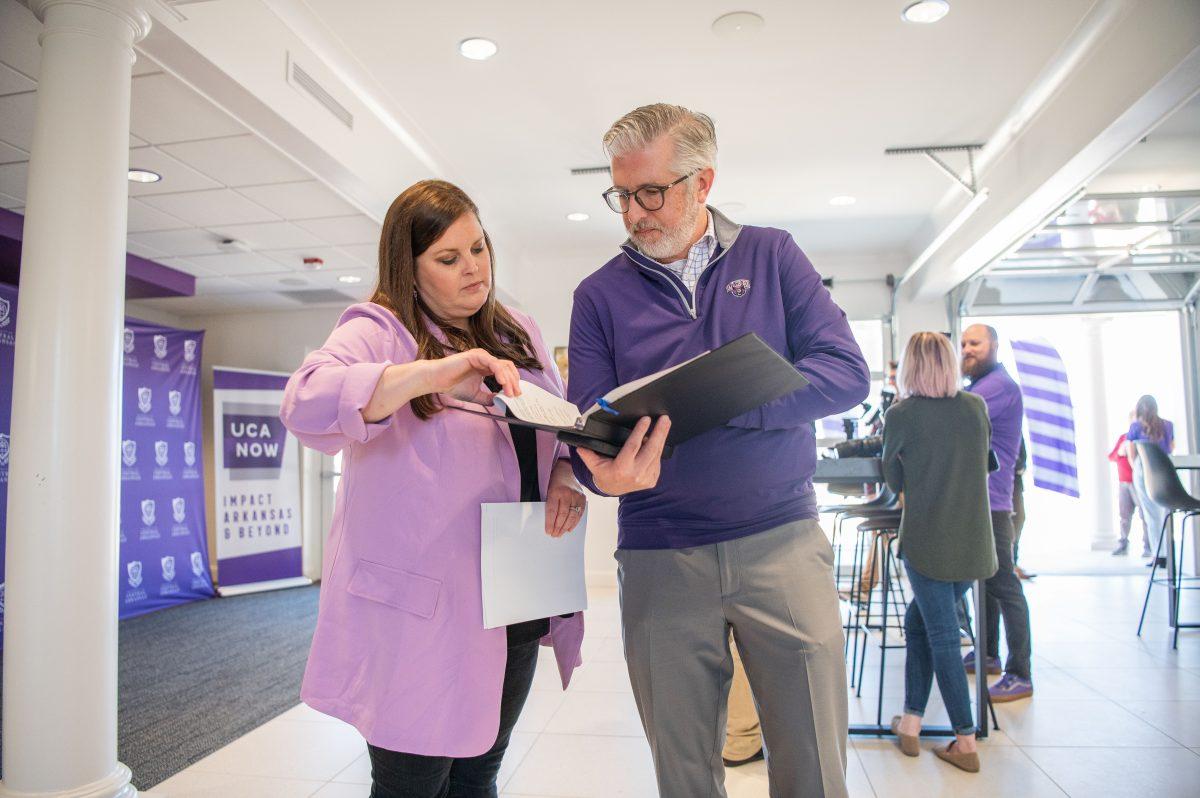 Senior Director of Annual Giving Haley Fowler shows President Houston Davis documents in a binder before his March 10 announcement. Davis said the 24-hour fundraising event raised the most it ever has in its nine-year history, with over $1.2 million raised, and saw over 90 groups help raise money.