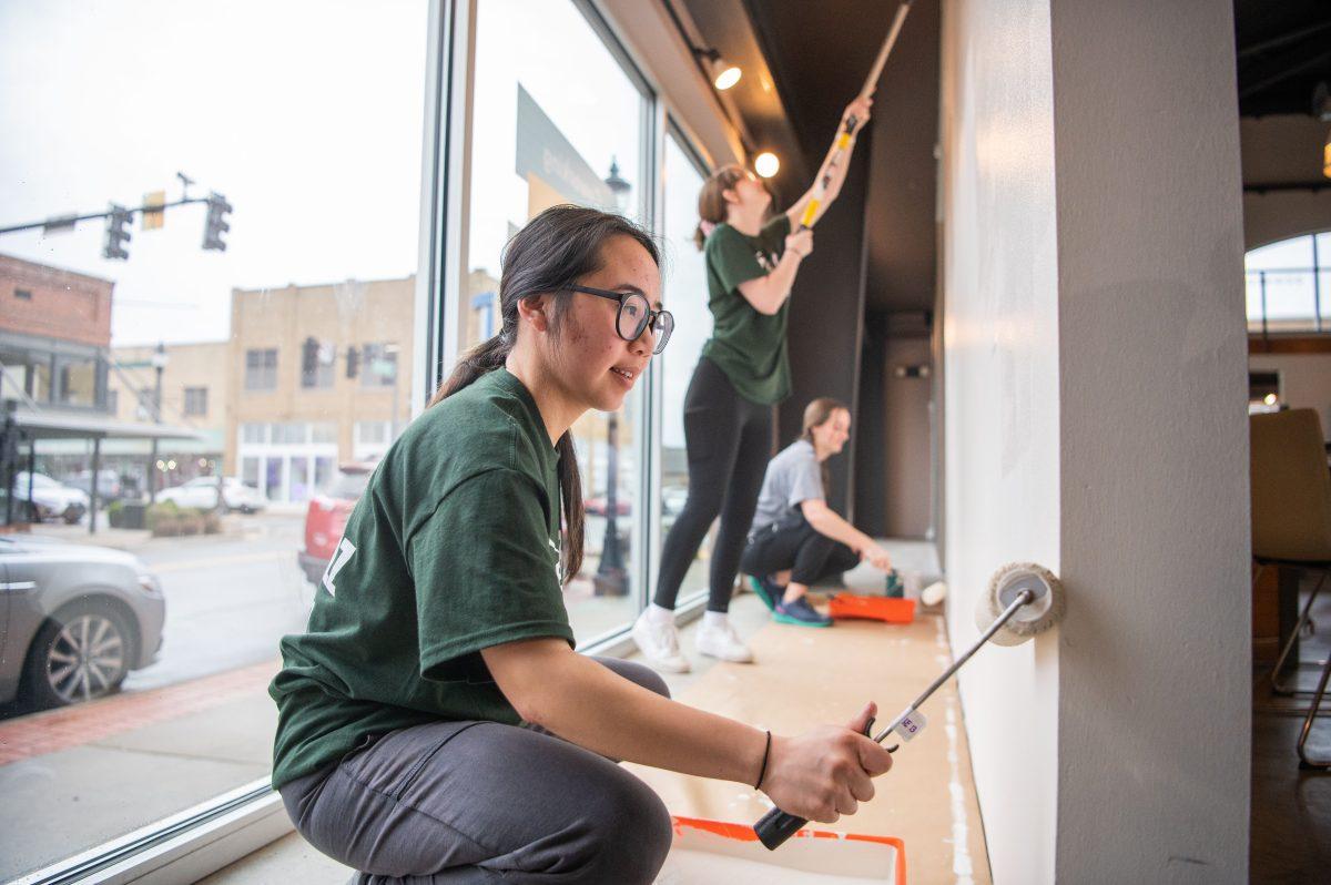 Students paint a wall at the Creative Institute of Central Arkansas at 1100 Oak St.