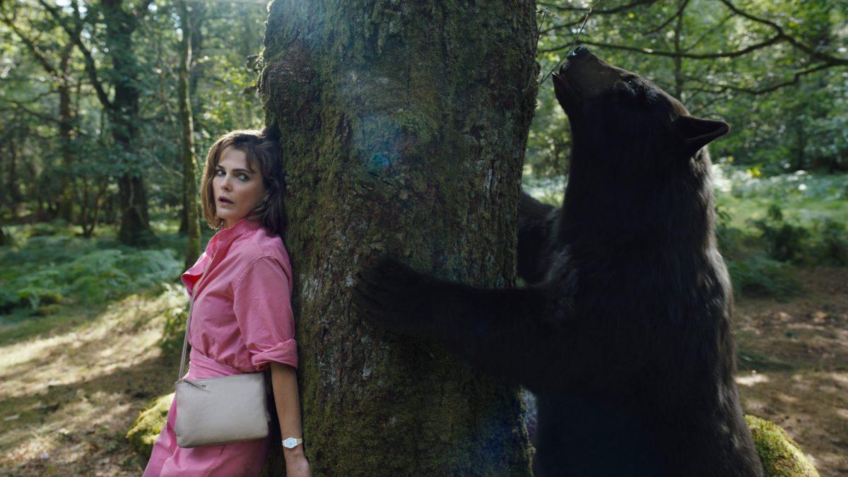 Keri Russell stars as Sari, seen hiding behind a tree from the titular bear. ‘Cocaine Bear’ was directed by Elizabeth Banks and released in theaters on Feb. 23.