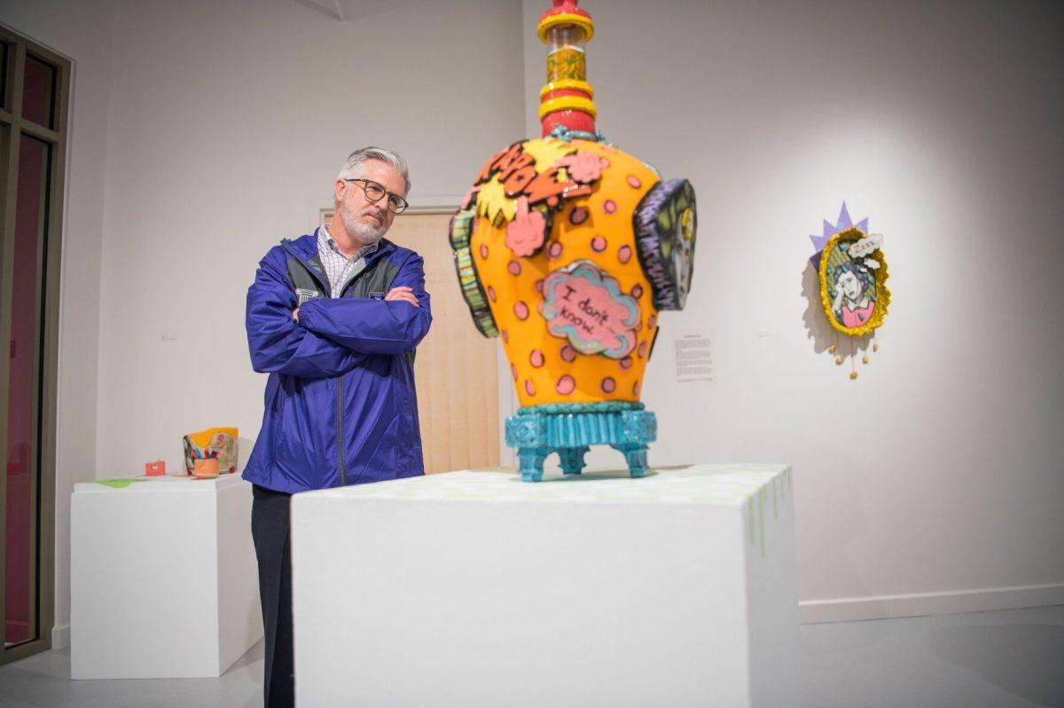 President Houston Davis observes art by Anna Wagner at the exhibit's Feb. 23 reception. Wagner was the first recipient of a $6,500 grant for alumni artists.