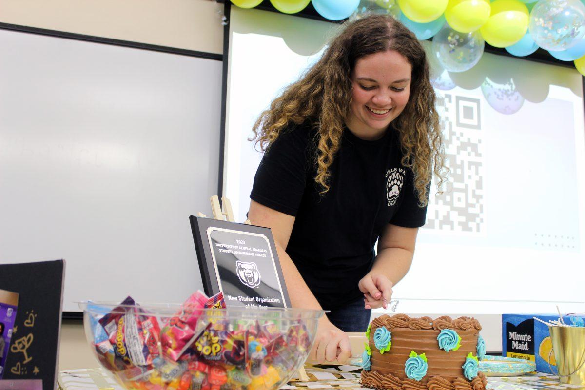Junior Abby Bounds, president of Girls Who Code, cuts cake to celebrate the club's one-year anniversary. The organization received a plaque for "New Student Organization of the Year."
