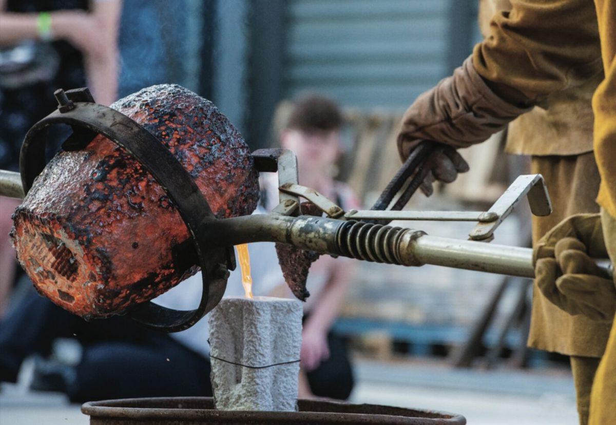 Bryan Massey, chair of the Department of Art and Design, pours molten bronze into a cast in front of an audience during the grand opening Sept. 21. The live pouring was one of many exhibitions and performances throughout the Windgate Center for Fine and Performing Arts. 