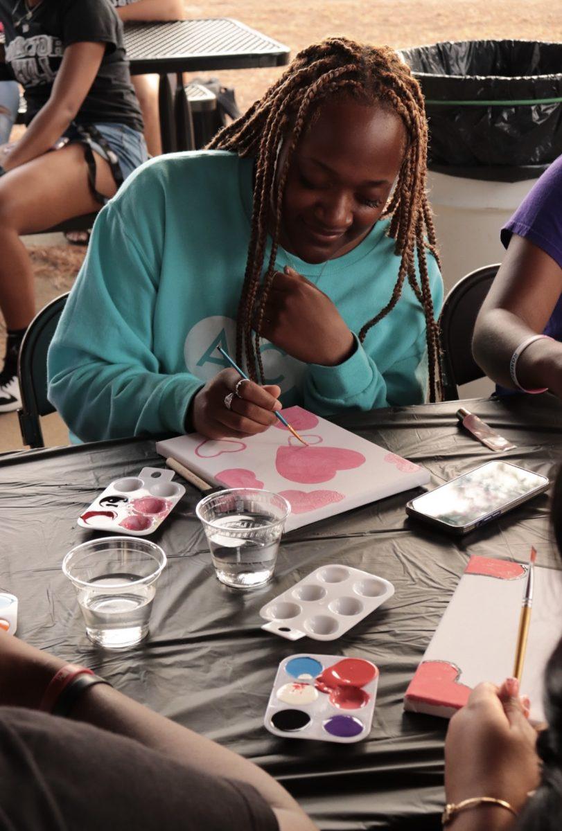A student paints hearts. The event was hosted by MMP.