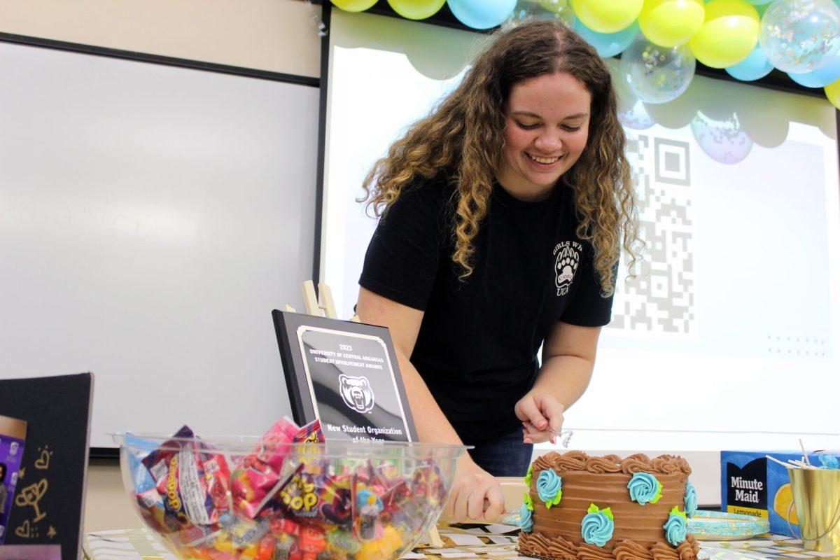 Junior Abby Bounds, president of Girls Who Code, cuts cake to celebrate the club's one-year anniversary. The organization received a plaque for "New Student Organization of the Year."
