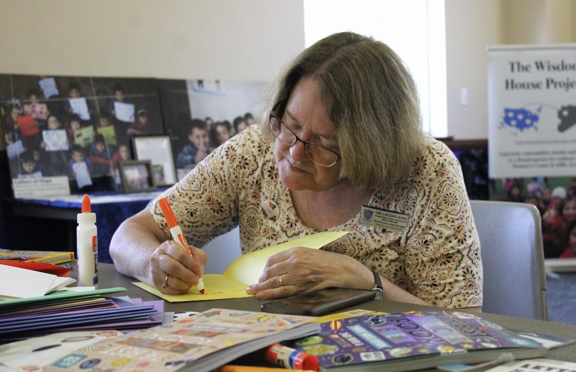 Pamela Woodard George, the manager for the international student and scholar services program, writes a letter of hope to children in Syria. The Letters of Hope event was sponsored by the Syrian Emergency Task Force.