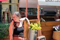 Britt Tubbs candidly leans against her business, Emmylou’s Flower Bar. Tubbs
refurbished an old horse trailer to make her flower stand.