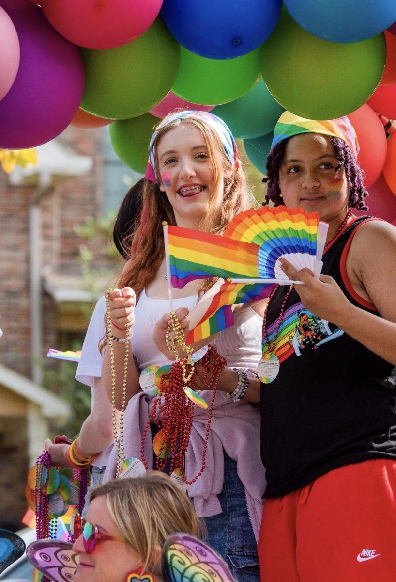 Young people hold Pride merchandise.