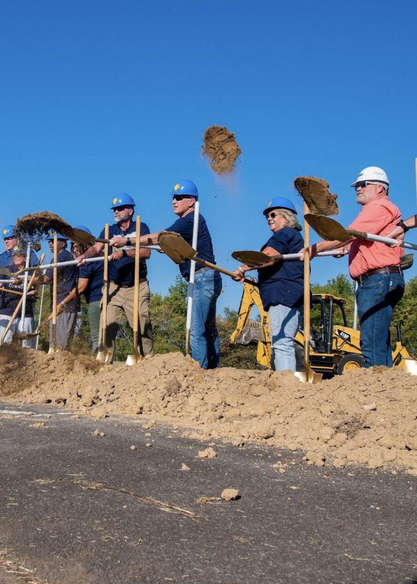 Conway Mayor Bart Castleberry and executives from Nabholz Construction shovel dirt at the groundbreaking ceremony. The Conway Community Center is set to open in 2025 and will feature a water park. 