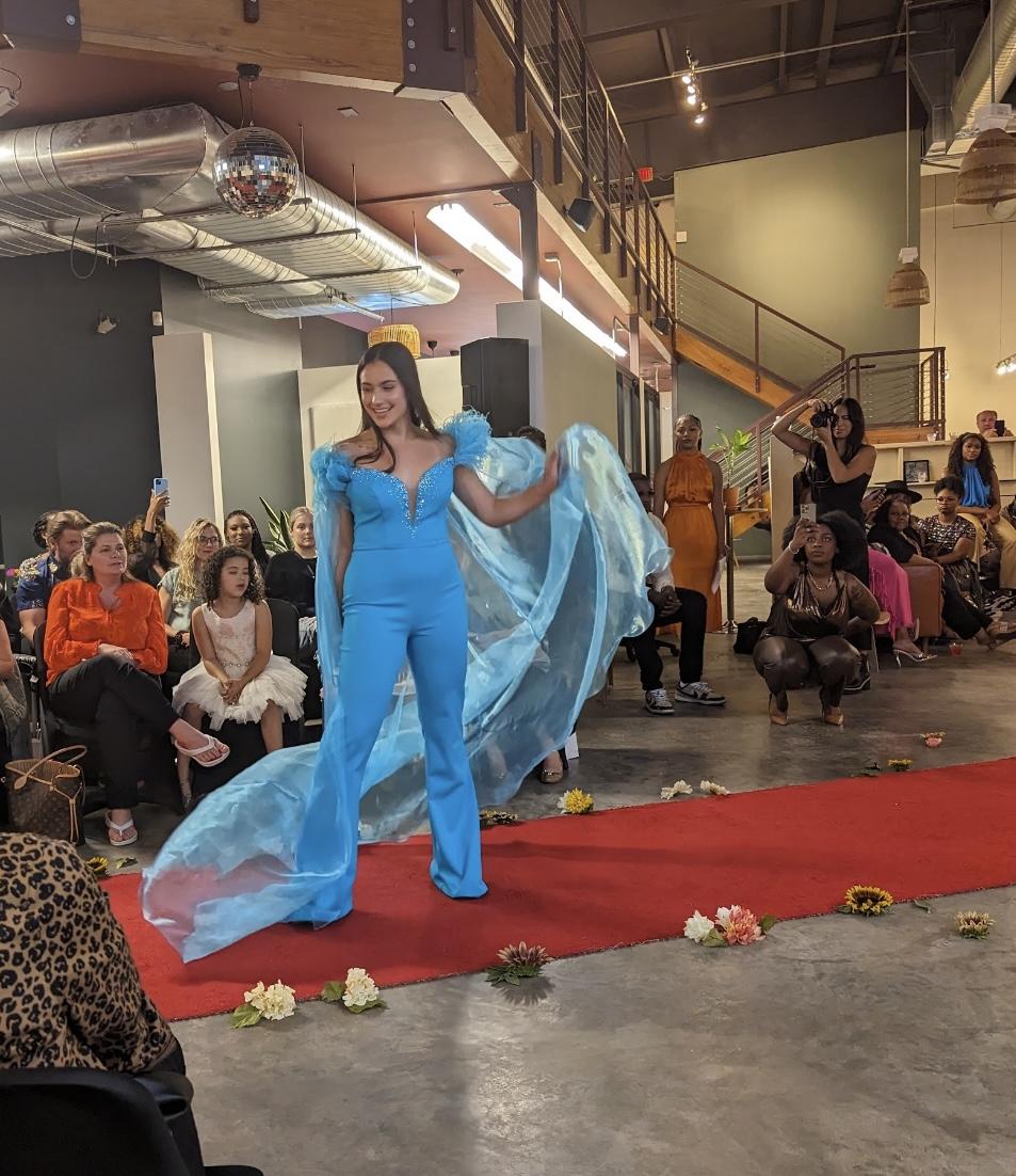  A model flaunts her cape while walking the runway.