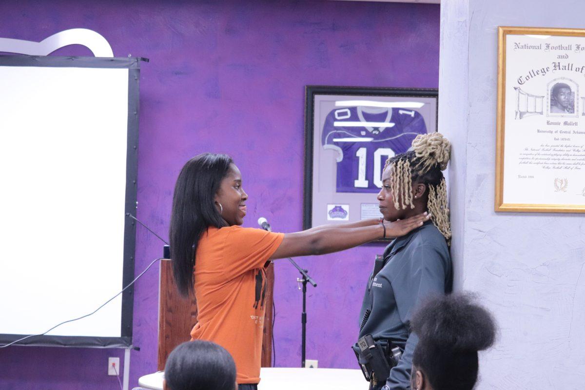 Women of Excellence Chaplain Jada Simpson practices self-defense moves with UCAPD officer Nicole Sumner-Wheeler.