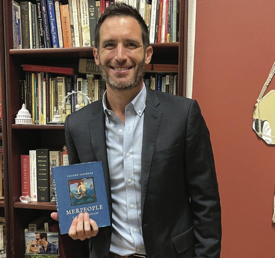 History professor Vaughn Scribner shows off his book "Merpeople: A Human History." Scribner wrote the book after historical accounts of their merpeople piqued his interest.