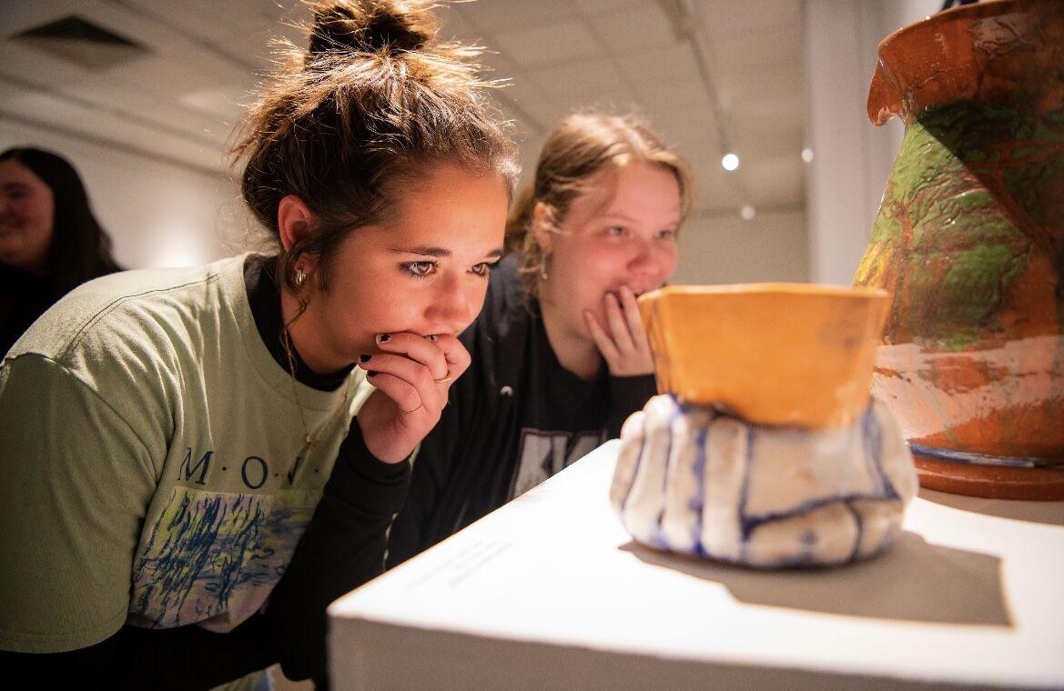 Students inspect the art displayed in the Baum Gallery. The opening night of the senior showcase was Nov. 2.