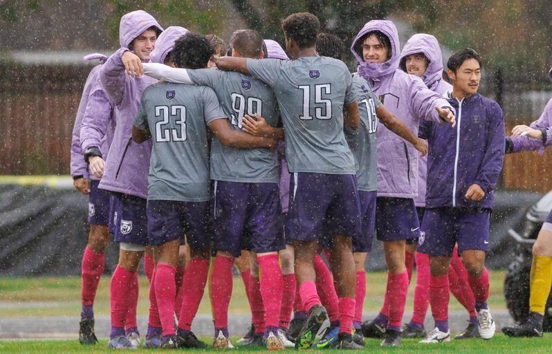 Sideline players congratulate teammates during the rainy match against the North Florida Ospreys. The Bears won the game 3-0 in a tense and fast quarrel. 