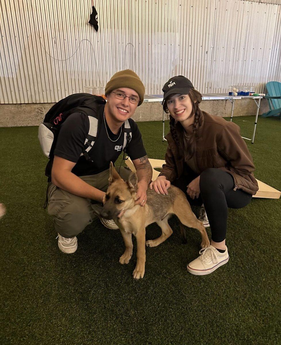 Tim and Megan Ruiz take a break from playing with their German Shepherd puppy, Montie.