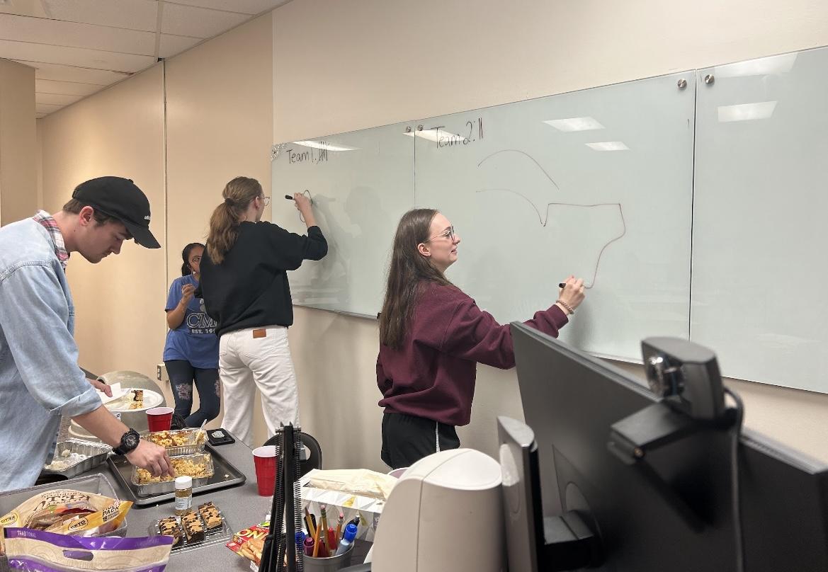 Students Maleah Behrens (left) and Anna Temple (right) play Pictionary. The Psych Society hosted a Friendsgiving Nov. 16 before the holiday break. 