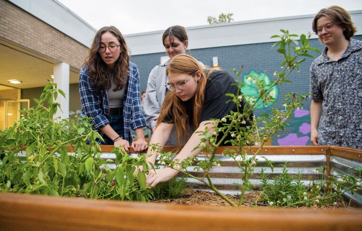 Three students work on the gardens in the newly renovated atrium Senior Cassia Cobb used the project for her capstone class. 