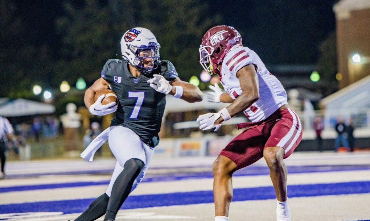 Junior running back Kylin James fends off an EKU defender. The Bears won the game in the last three seconds of the fourth quarter, with a fina score of 27-24.