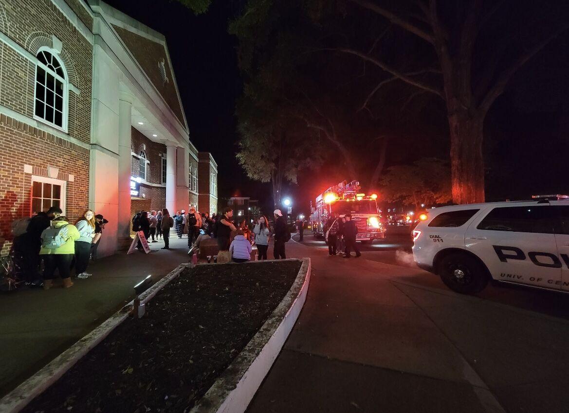 A fire truck arrives on the scene as students stand around Torreyson Library. Staff evacuated the building after people smelled smoke, which came from a faulty server in a technical closet.