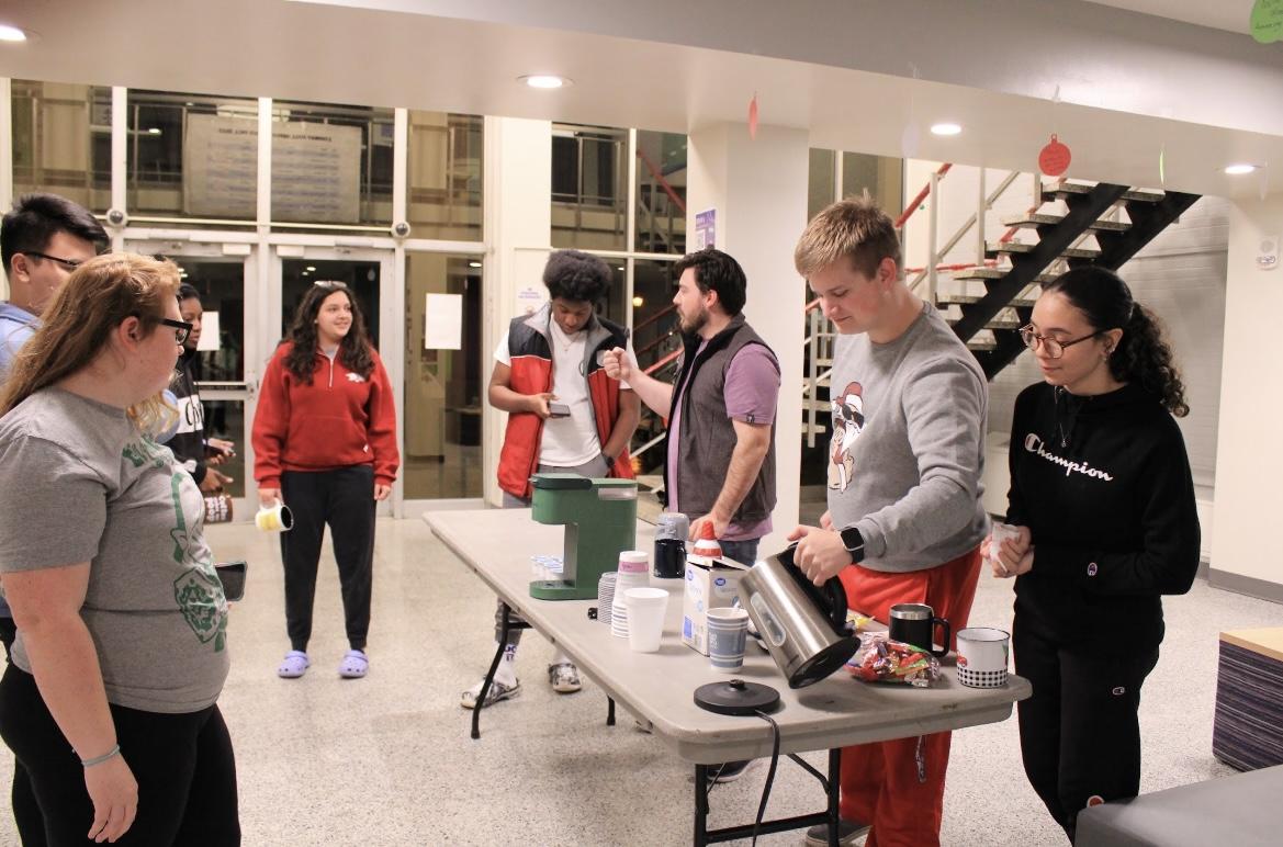 Students line up for hot chocolate, whipped cream, sprinkles and more at the Bernard Hall holiday event.Attendees discussed their favorite Christmas movies.  