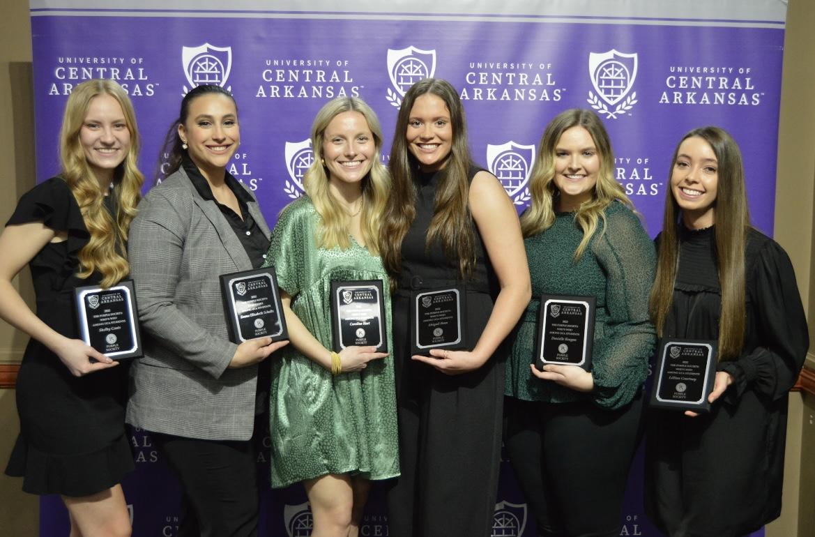 Students hold their Purple Society plaques at the April 2023 event. The 2024 applications for Purple Society are open until Jan. 19.
