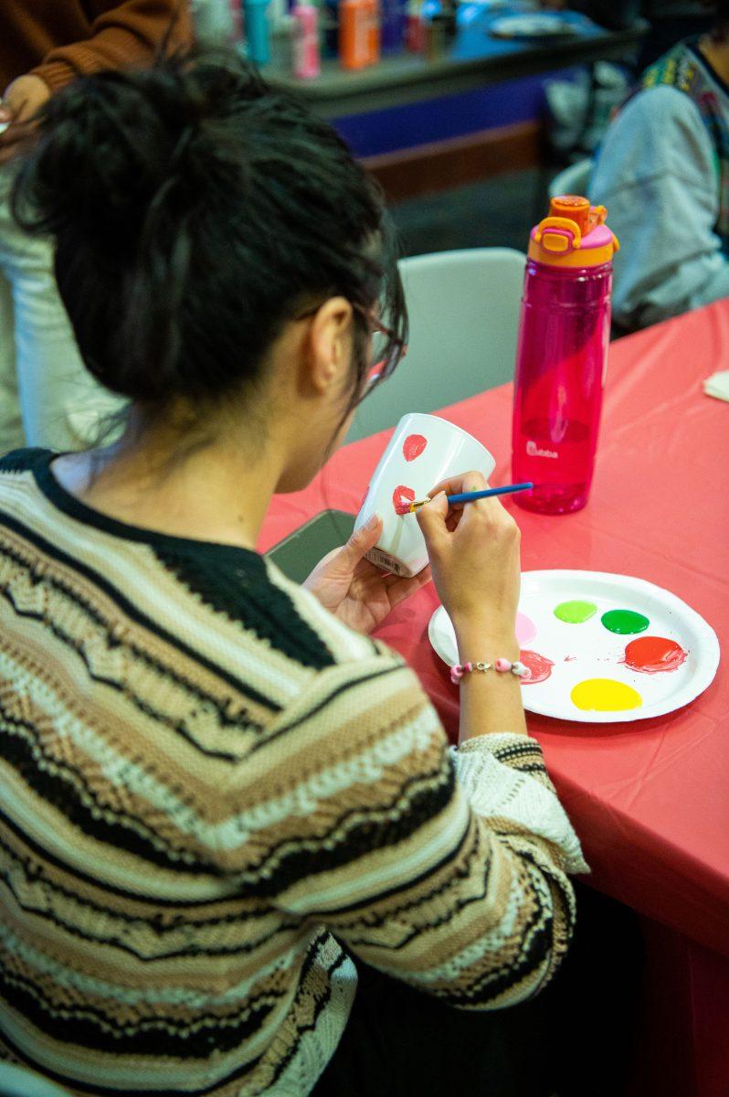 An attendee decorates her mug with pastel paints. SIA will host another event Feb. 29.