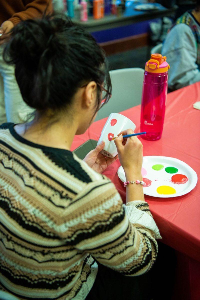 An attendee decorates her mug with pastel paints. SIA will host another event Feb. 29.