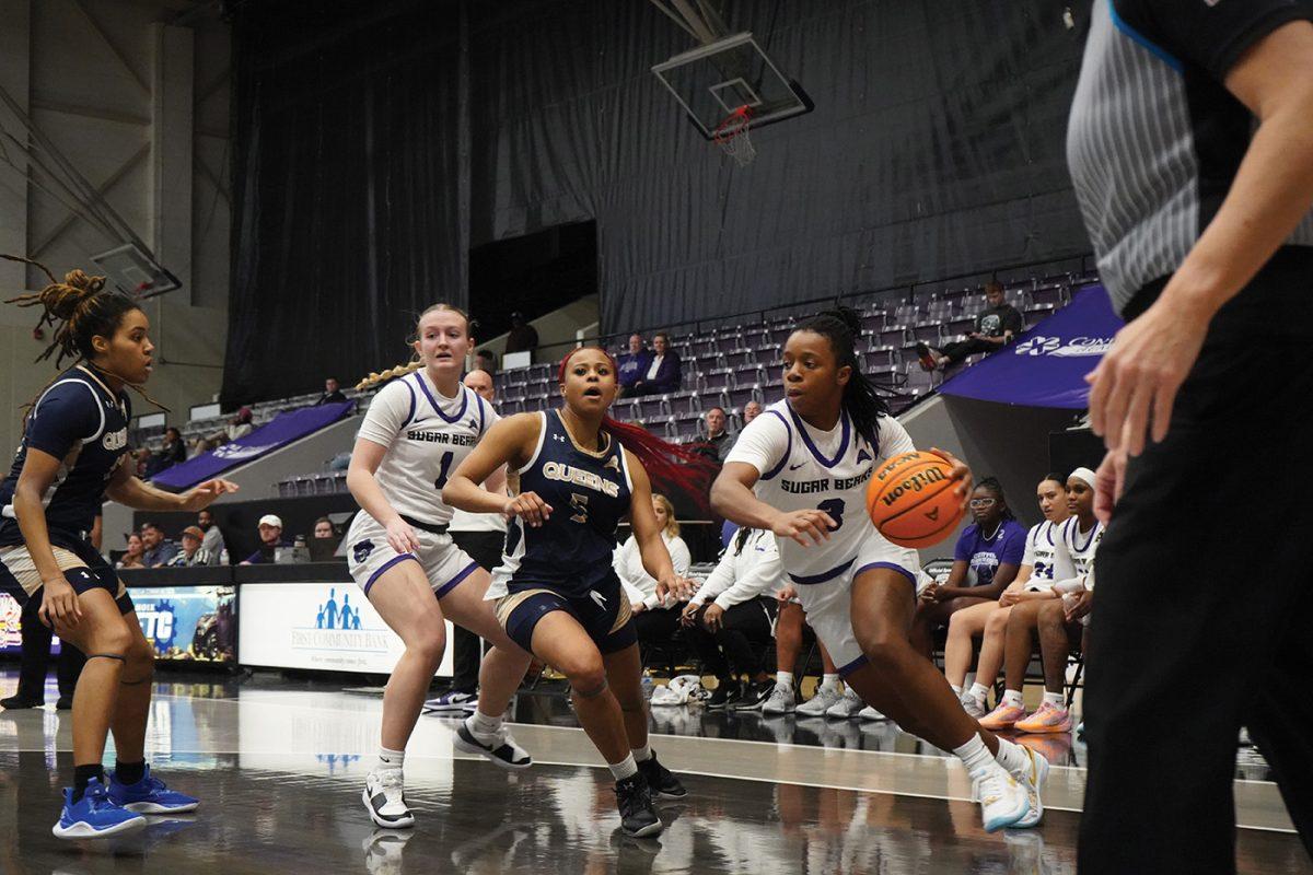 Junior guard Randrea Wright tries to dribble past Queens player junior guard Tameia Shaw. Wright has made a total of 522 shots this season.